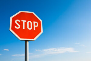 A red octagonal stop sign against a clear blue sky.