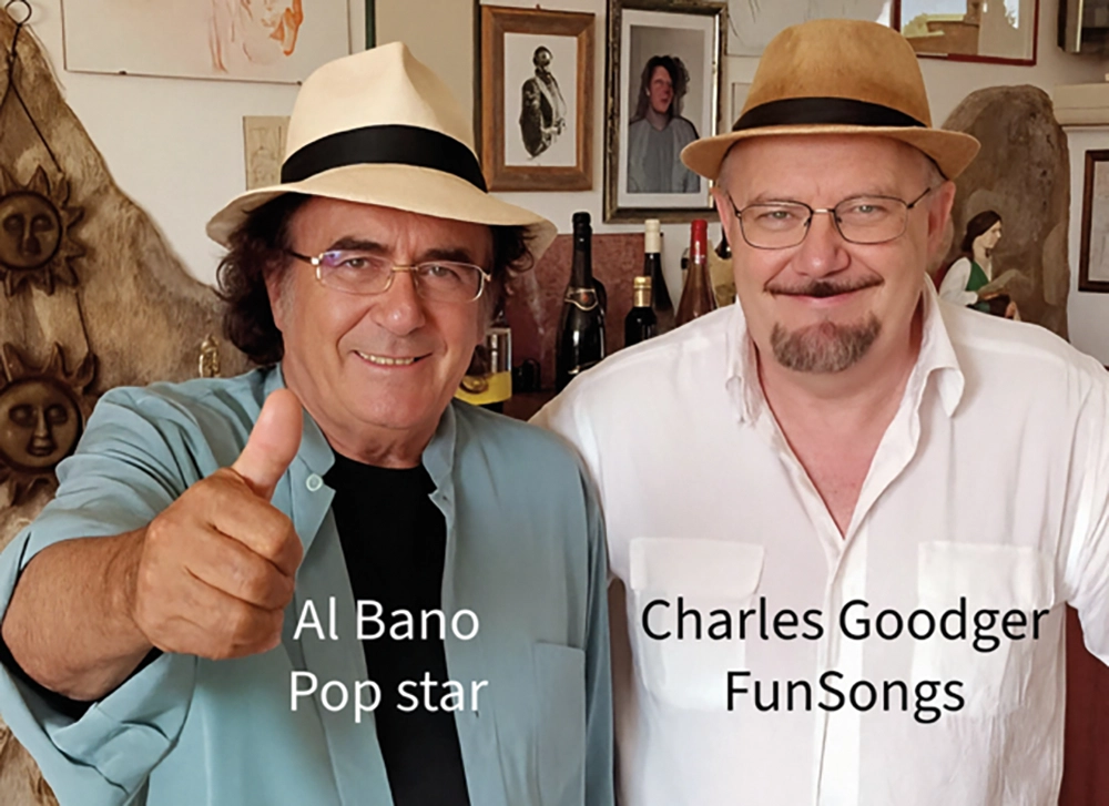 Two men wearing hats and glasses are standing side by side indoors, with various artworks and bottles visible in the background. One man is giving a thumbs-up gesture and smiling.