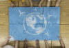 Rethinking sustainability: it starts with being self-sustainable Children assembling a large blue puzzle featuring a chalk drawing of Earth with symbols of renewable energy, including wind turbines and solar panels.