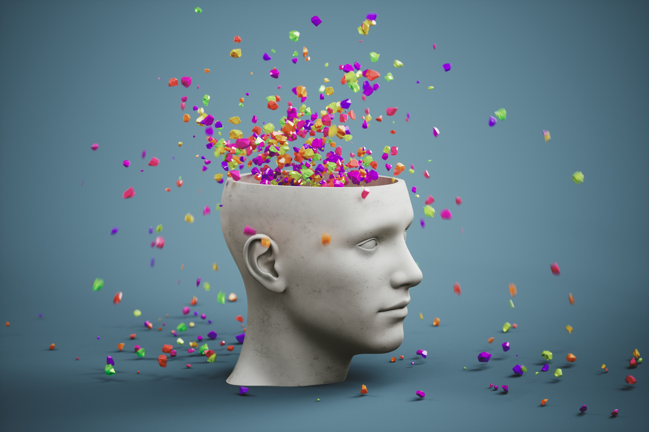 A white sculpted head with an open top, showing colourful geometric shapes floating out against a blue background.