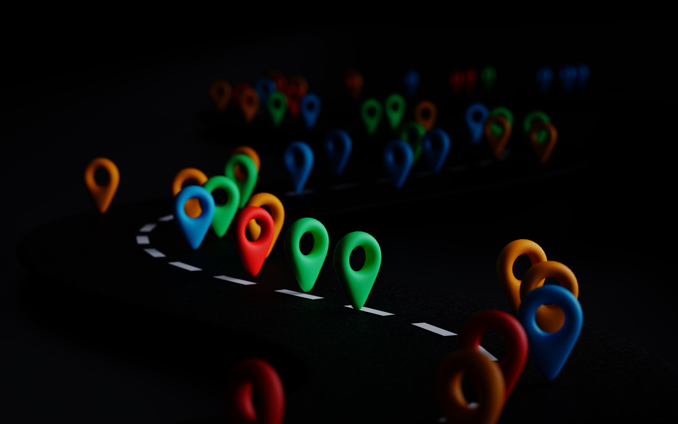A series of multicoloured 3D location markers, including red, blue, green, and yellow, placed in a curved pattern resembling a road against a dark background.