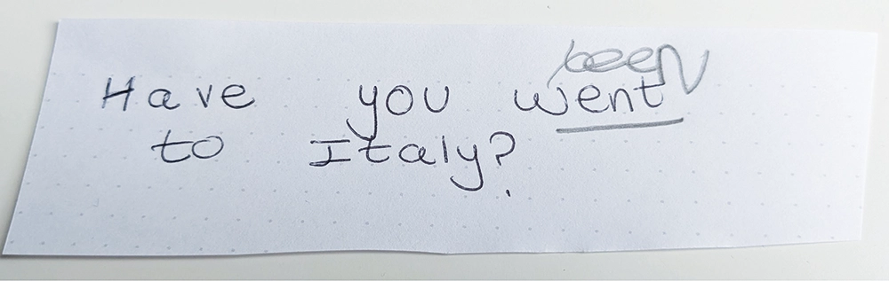 A piece of paper with the handwritten question "Have you went to Italy?" with the word "went" crossed out and "been" written above it.
