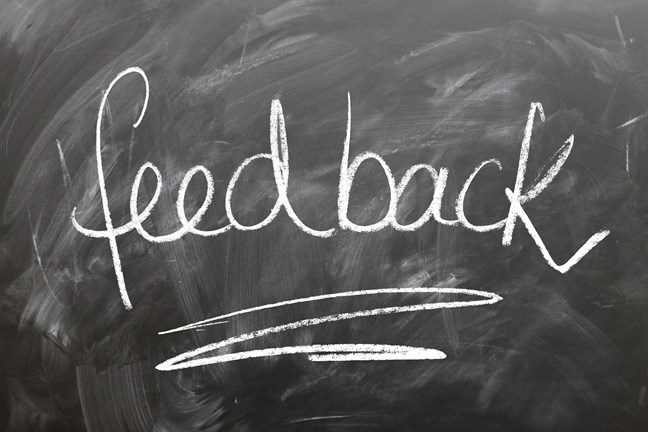 The word 'feedback' written in white chalk on a blackboard with a line underscoring it.