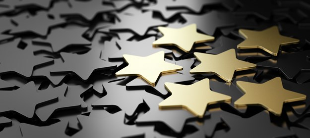 Gold stars scattered on a glossy black surface.