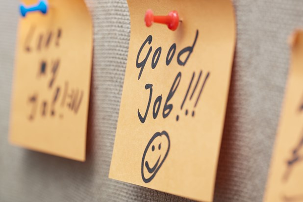 A sticky note on a board with the handwritten message 'Good Job!!!' and a smiley face, pinned with a red thumbtack.