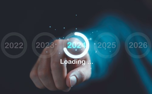 A hand is pointing towards a 3D-like digital display showing years 2022 to 2026, with the year 2024 highlighted in a loading circle and the word 'Loading...' beneath it.