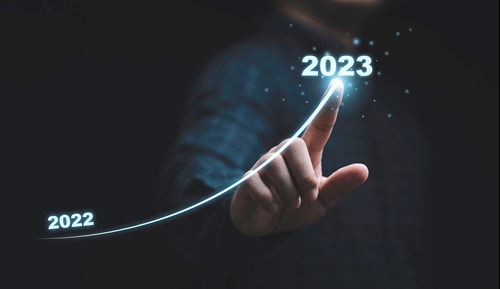 A person is touching a glowing line that curves upwards from 2022 to 2023, symbolizing growth or progress.