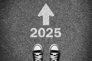 Black and white photo of a pair of sneakers standing on asphalt, with the number 