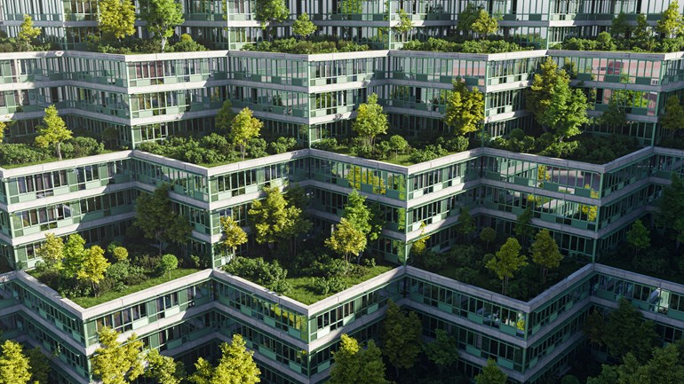 Aerial view of a modern building complex with a tiered, zigzag design, featuring lush green trees and plants growing on each level.
