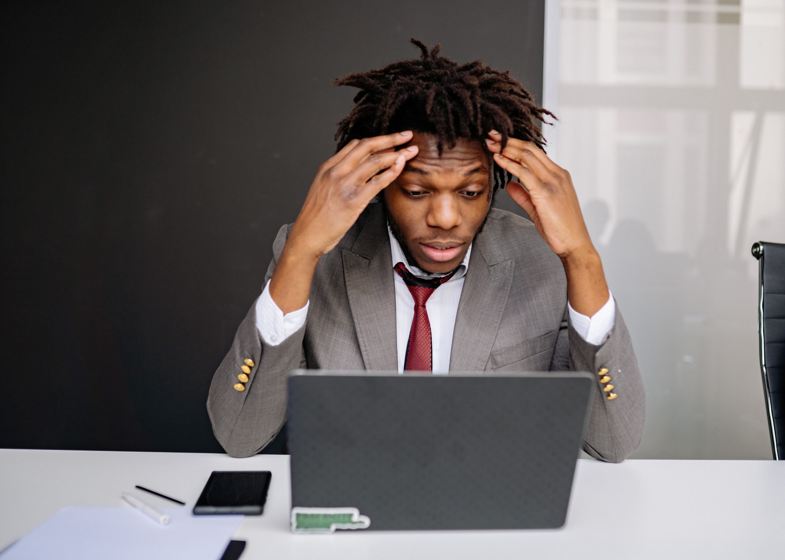 man in suit frustrated at laptop