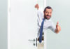 Flipping DELTA A man wearing a white shirt and blue tie leans through a partially open white door, smiling and giving a thumbs up.