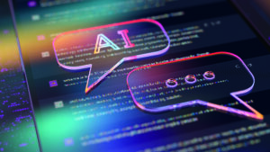 A digital illustration featuring two holographic speech bubbles overlaid on computer code. One bubble contains the letters "AI" while the other shows ellipses, suggesting an ongoing conversation or dialogue. The image is enhanced with vibrant, neon colours, creating a futuristic and dynamic atmosphere.
