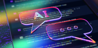 A digital illustration featuring two holographic speech bubbles overlaid on computer code. One bubble contains the letters "AI" while the other shows ellipses, suggesting an ongoing conversation or dialogue. The image is enhanced with vibrant, neon colours, creating a futuristic and dynamic atmosphere.