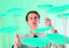 Finding the learning opportunities A person skillfully balances multiple green spinning plates on wooden sticks, concentrating on maintaining their spin, against a green background.