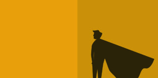A small figure stands confidently with arms crossed, casting a large shadow on the wall resembling a superhero with a cape, in a minimalist style with a warm yellow background.