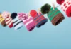 My mix of hats A row of colourful knitted miniature hats with pom-poms, clipped to a line with small wooden pegs against a light blue background.
