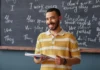 The rhythms of language: embracing reading aloud A smiling man wearing a yellow and white striped shirt holds a notebook in a classroom, standing in front of a blackboard with handwritten sentences.