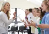 Meaning in sound A music teacher conducting a children's choir indoors, with students holding sheets of music and singing.