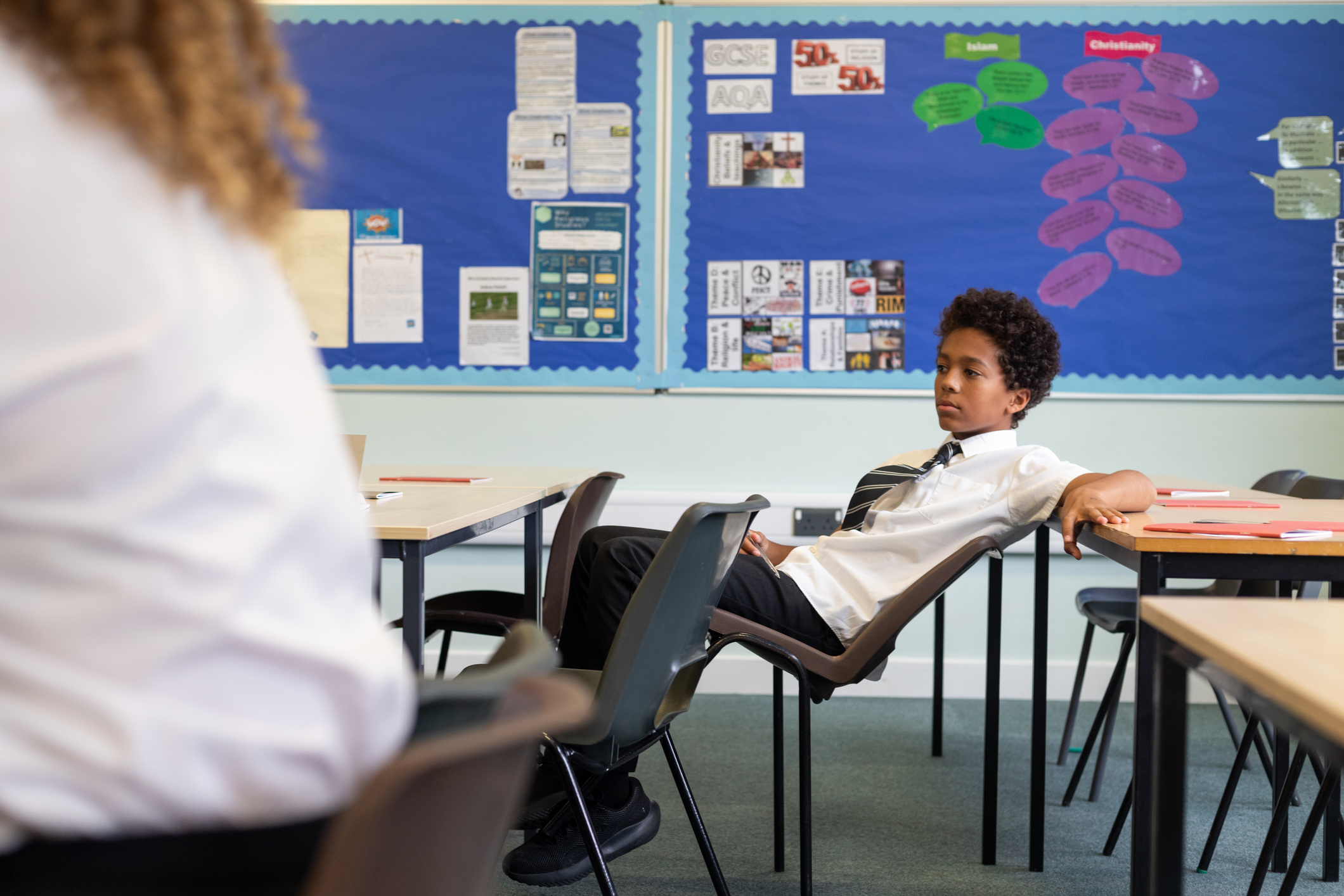 Schoolboy Swinging on a Chair in the Classroom