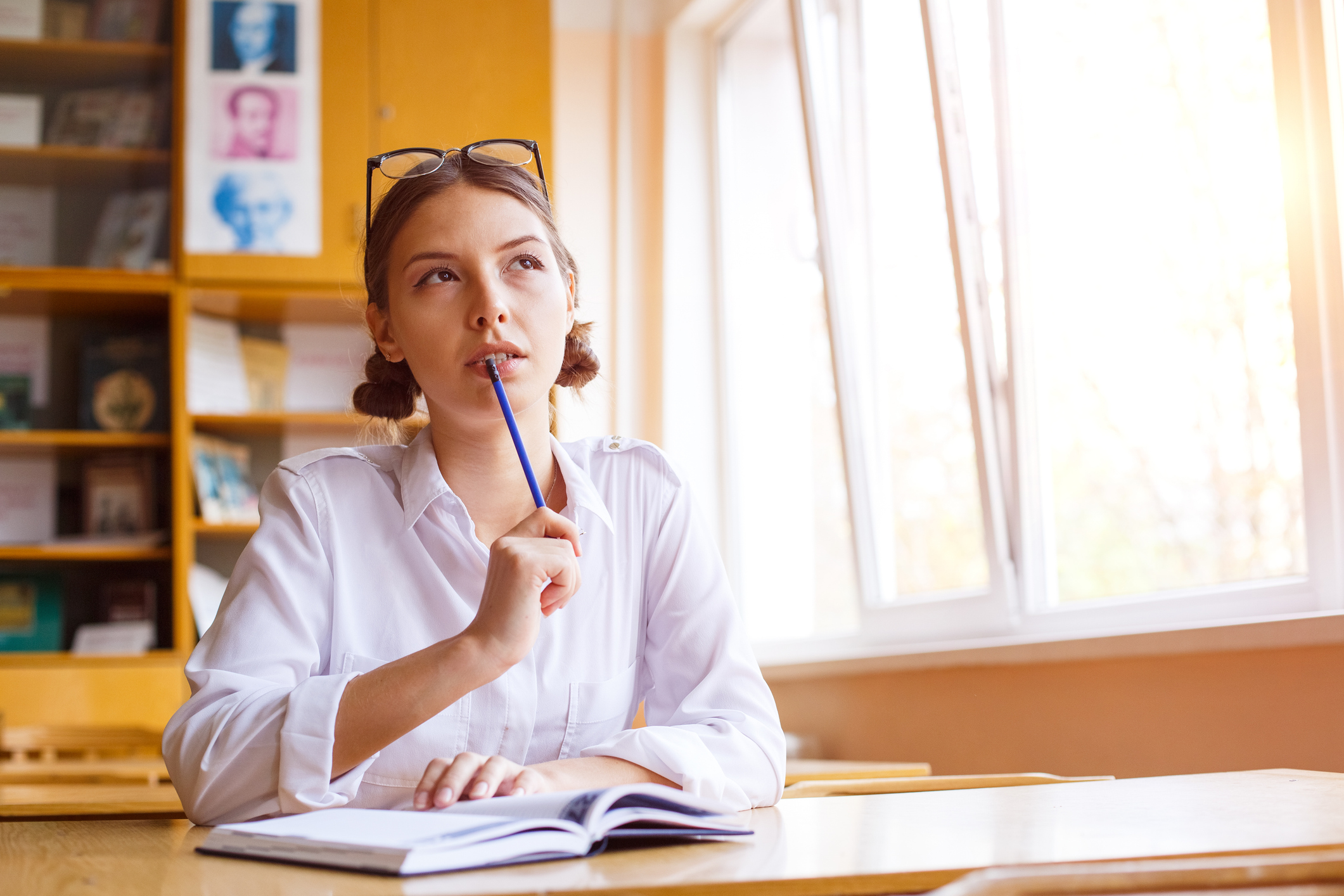 Young woman studying for test exam. Tutor writes books in notebook