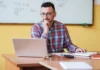 How to write the introduction in IELTS writing teacher at desk looking at laptop