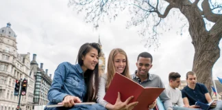 Taking the plunge three students in a park sharing a book