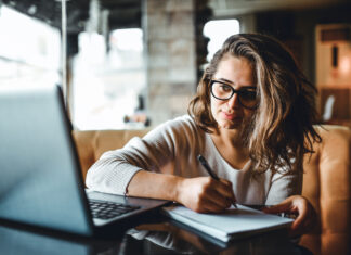 I want to write, but how? Woman writing with pen and paper while at laptop